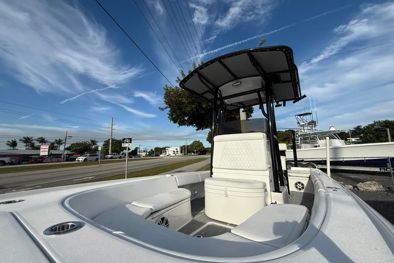 Slide: The Image of 2021 Contender 25 Bay boat with T-top, parked roadside under blue sky. - 15