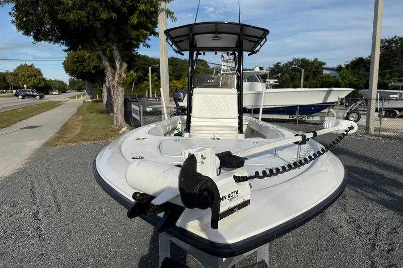 Slide: The Image of 2021 Contender 25 Bay boat with Minn Kota trolling motor, parked on gravel. - 18