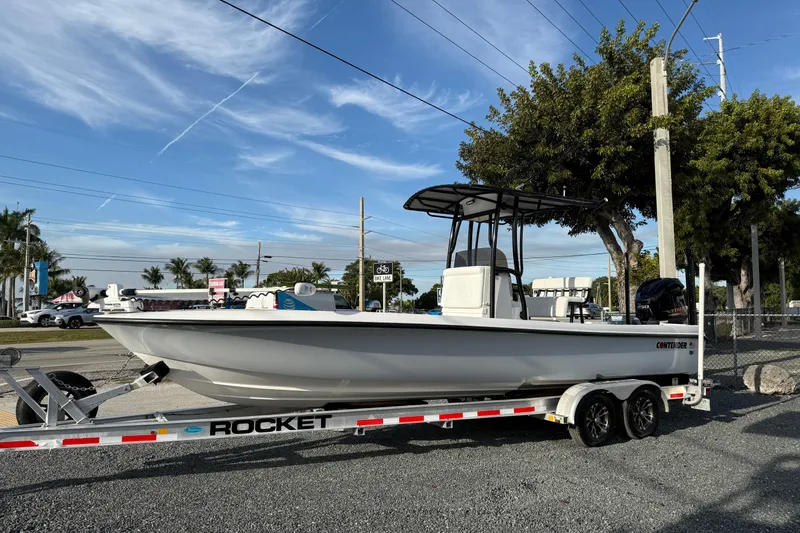 Slide: The Image of 2021 Contender 25 Bay boat on trailer, parked outdoors under a clear sky. - 2