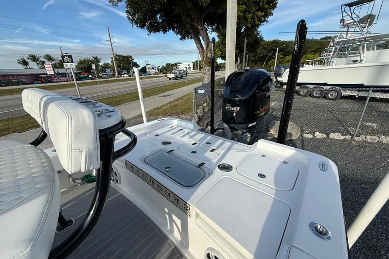 Slide: The Image of 2021 Contender 25 Bay boat with powerful 250 engine, parked near a road. - 7