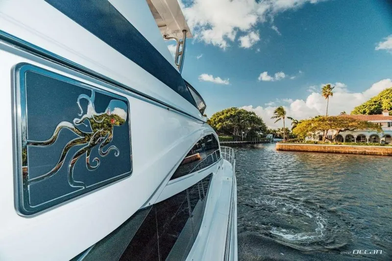 Slide: The Image of 2017 Sea Ray L650 Fly yacht cruising near a scenic waterfront with palm trees. - 10