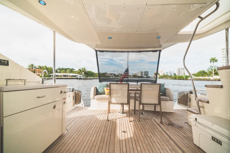 Slide: The Image of Luxurious 2017 Sea Ray L650 Fly yacht deck with seating, table, and waterfront view. - 33