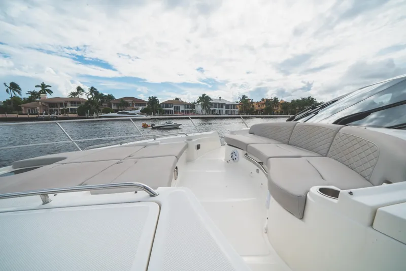 Slide: The Image of Luxurious 2017 Sea Ray L650 Fly yacht with spacious deck seating, docked by waterfront homes. - 38