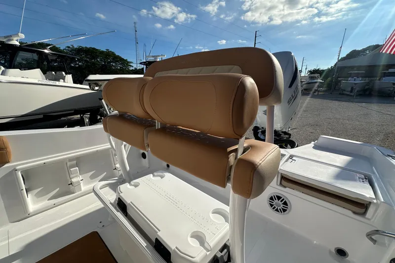 Slide: The Image of 2025 NauticStar 231 Hybrid boat interior with tan seating and storage compartments. - 13