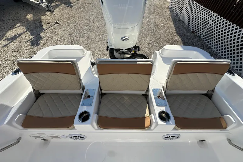 Slide: The Image of 2025 NauticStar 231 Hybrid boat seats with beige cushions and cup holders. - 17