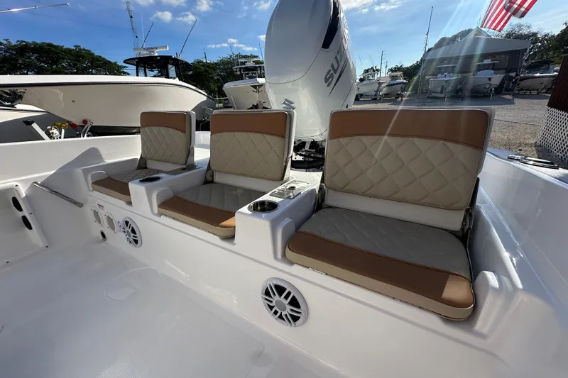 Slide: The Image of 2025 NauticStar 231 Hybrid boat interior with cushioned seating and cup holders. - 18
