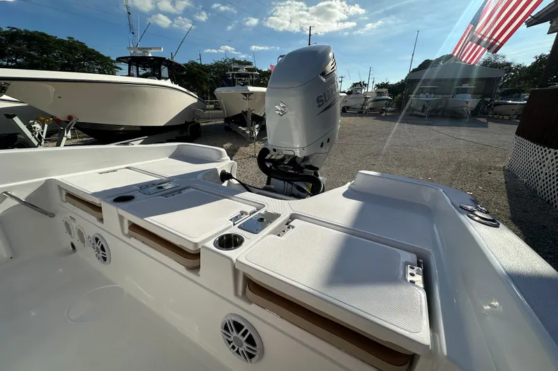 Slide: The Image of 2025 NauticStar 231 Hybrid boat with Suzuki outboard motor in a sunny marina. - 19