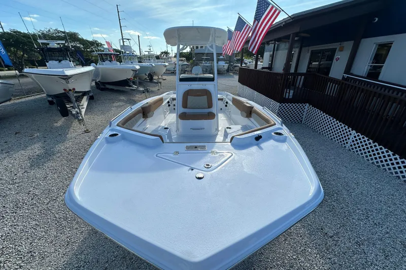 Slide: The Image of 2025 NauticStar 231 Hybrid boat displayed outdoors with American flags. - 3