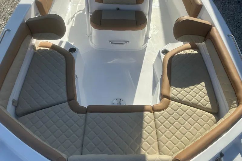 Slide: The Image of 2025 NauticStar 231 Hybrid boat interior with tan quilted seating and cup holders. - 8