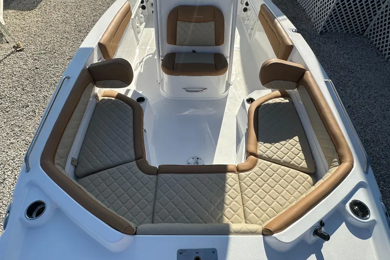 Slide: The Image of 2025 NauticStar 231 Hybrid boat interior with tan and beige cushioned seating. - 9