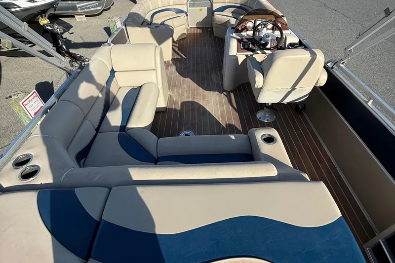 Slide: The Image of 2012 Berkshire 210CL Premium pontoon boat interior with beige and blue seating. - 11