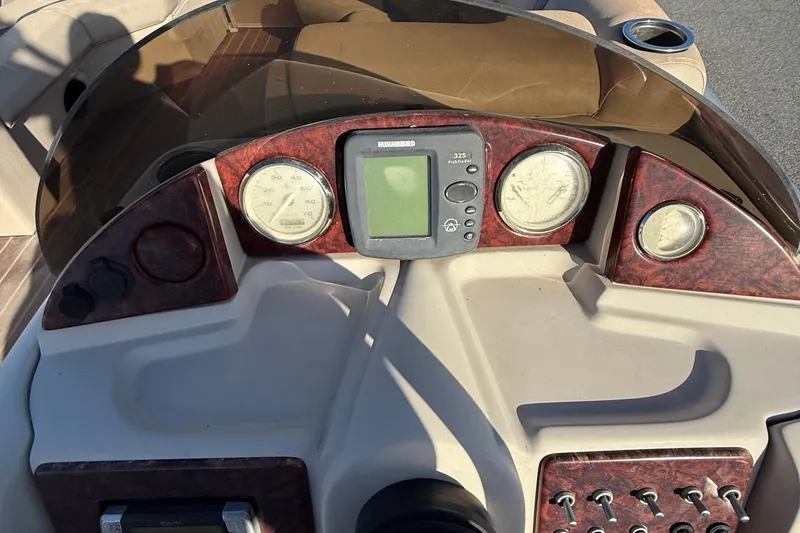 Slide: The Image of Control panel of a 2012 Berkshire 210CL Premium boat with gauges and electronics. - 14