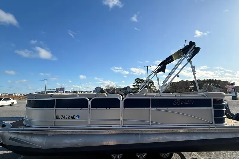 Slide: The Image of 2012 Berkshire 210CL Premium pontoon boat parked under a clear blue sky. - 5