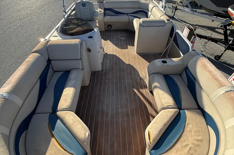Slide: The Image of 2012 Berkshire 210CL Premium pontoon boat interior with beige and blue seating. - 9