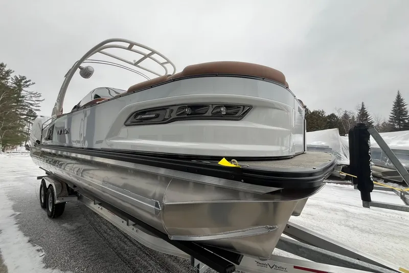 Slide: The Image of 2026 Avalon Excalibur LTD Quad Lounge pontoon boat on trailer in snowy setting. - 5