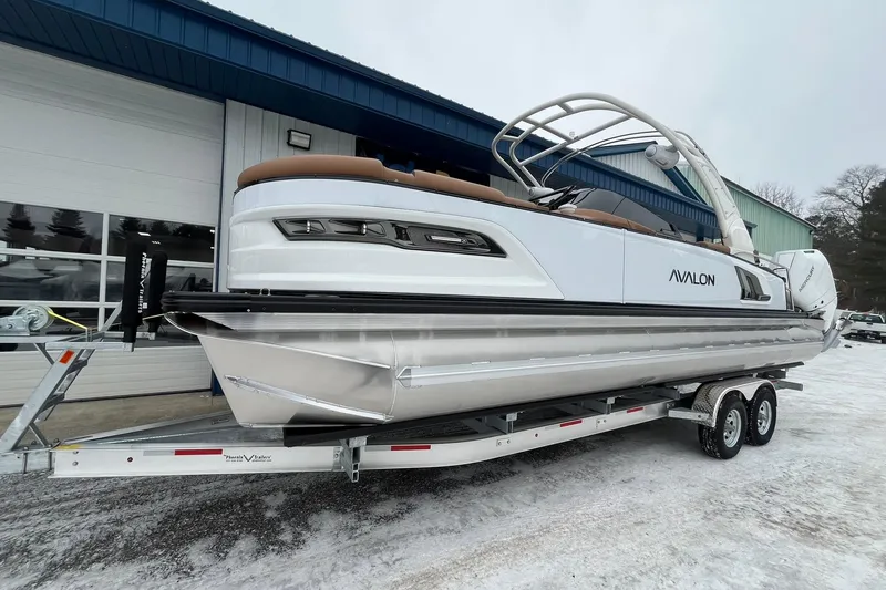 Slide: The Image of 2026 Avalon Excalibur LTD Quad Lounge pontoon boat on trailer, snowy background. - 7
