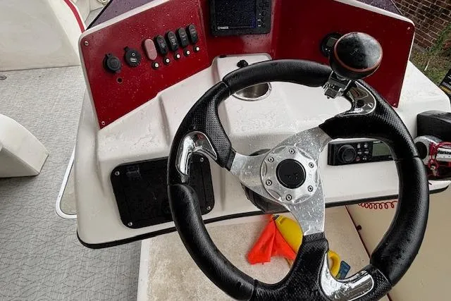 Slide: The Image of Steering console of 2022 Aloha Pontoon Tropical 260 with controls and instruments. - 14