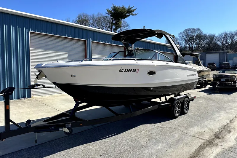 The Image of 2021 Chaparral 26 Surf boat on trailer, parked outside storage facility. - 0