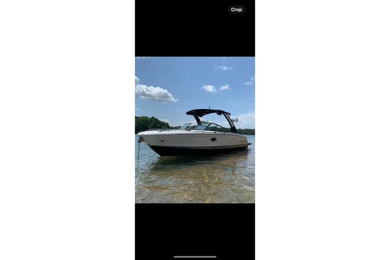 Slide: The Image of 2021 Chaparral 26 Surf boat on clear water under blue sky. - 17