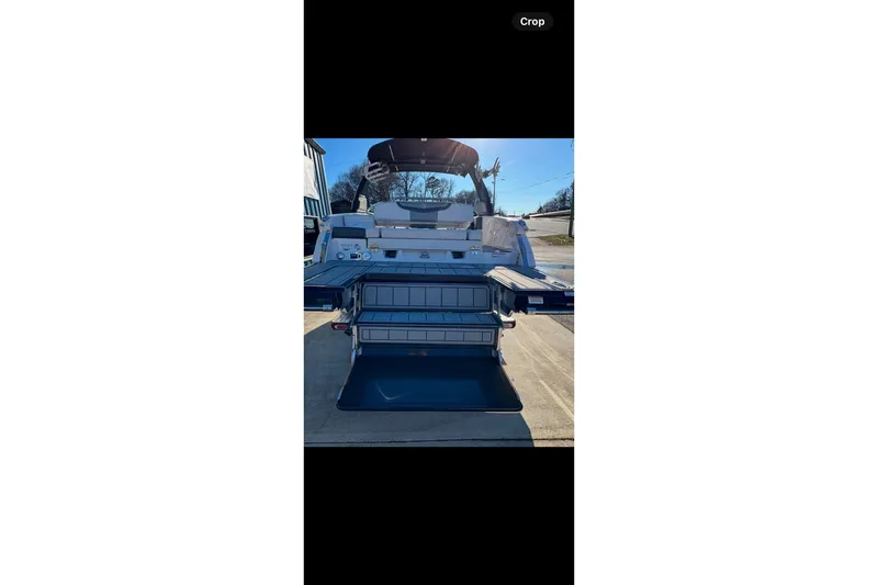 Slide: The Image of 2021 Chaparral 26 Surf boat, rear view with open storage compartments. - 19