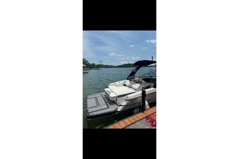Slide: The Image of 2021 Chaparral 26 Surf boat docked on a sunny lake. - 20