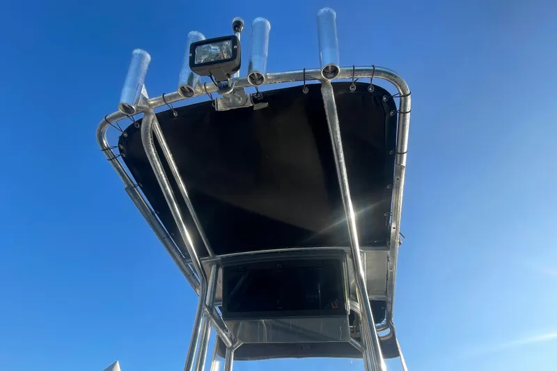 Slide: The Image of 2016 Zodiac Pro Classic 650 boat canopy with rod holders and light against blue sky. - 7