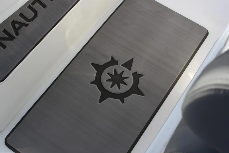 Slide: The Image of 2025 NauticStar 251 Hybrid boat deck with compass logo detail. - 14