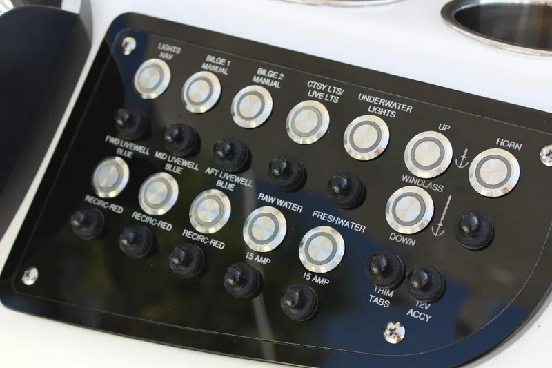 Slide: The Image of Control panel of 2025 NauticStar 251 Hybrid boat with various switches and buttons. - 18