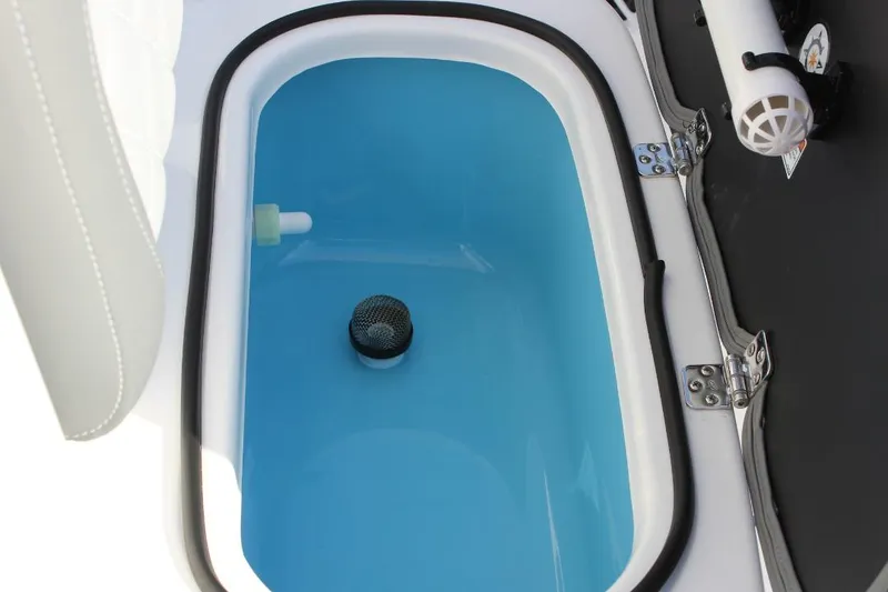 Slide: The Image of Livewell compartment on 2025 NauticStar 251 Hybrid boat, featuring blue interior and secure latch. - 28