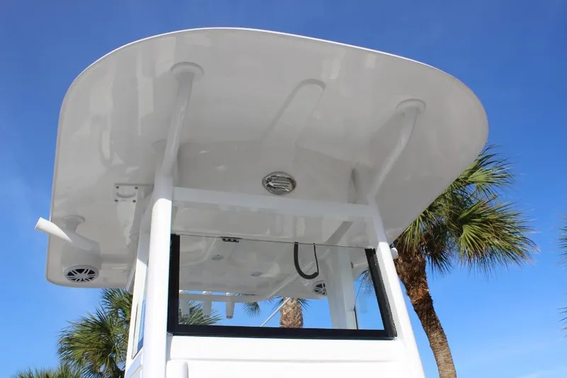 Slide: The Image of 2025 NauticStar 251 Hybrid boat top view with clear blue sky and palm trees. - 29