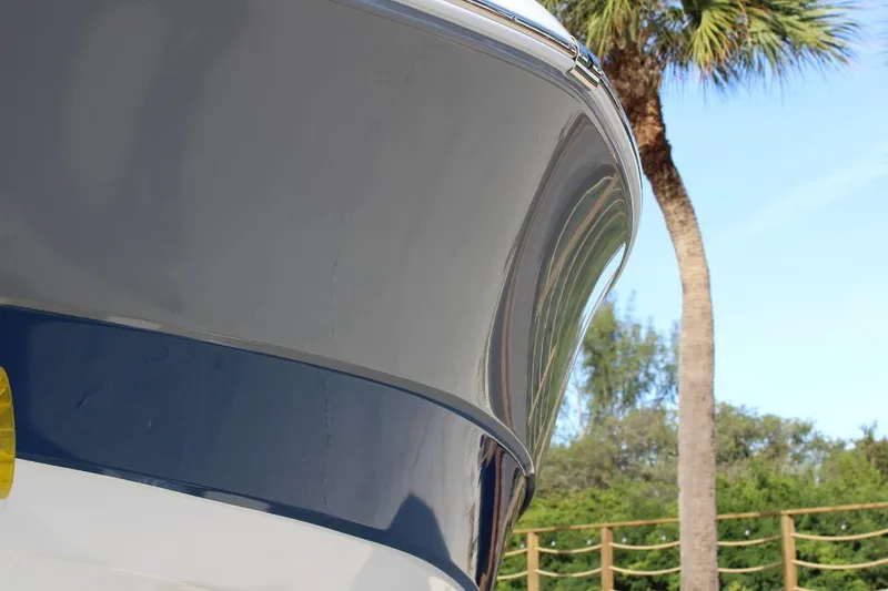 Slide: The Image of 2025 NauticStar 251 Hybrid boat bow with palm tree background. - 5