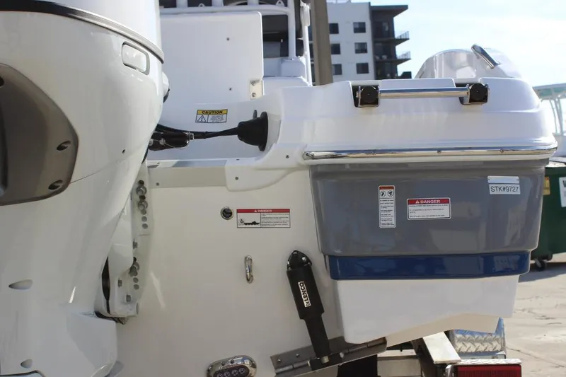 Slide: The Image of 2025 NauticStar 251 Hybrid boat stern with engine and safety labels. - 8