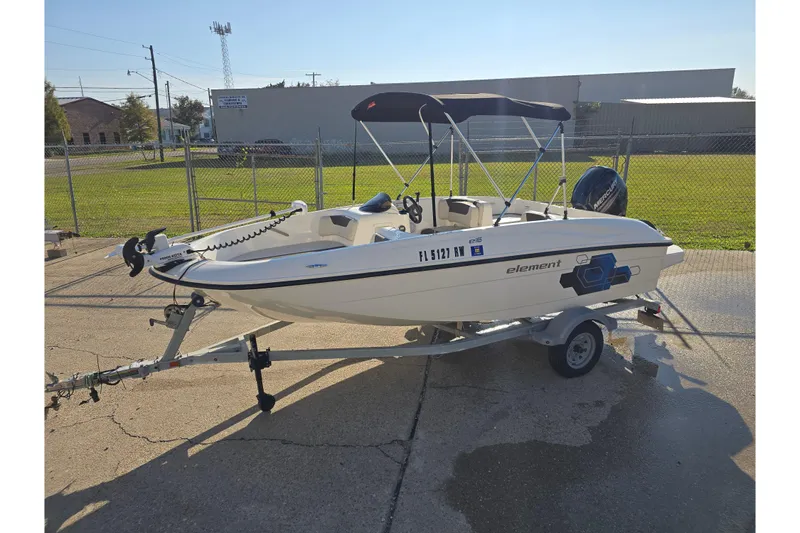 Slide: The Image of 2019 Bayliner Element E16 boat on trailer, parked outdoors. - 2