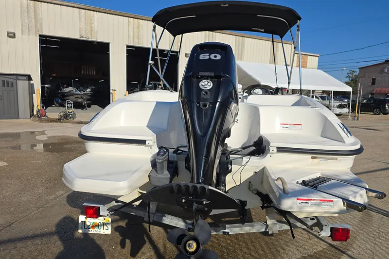 Slide: The Image of 2019 Bayliner Element E16 boat with outboard motor, parked outside a warehouse. - 8