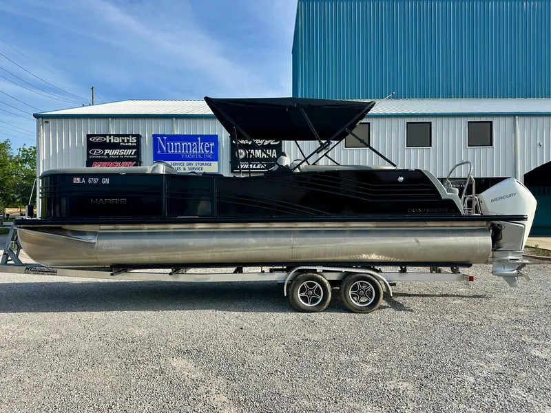 The Image of 2021 Harris Grand Mariner 250 pontoon boat on trailer, parked outside a building. - 1