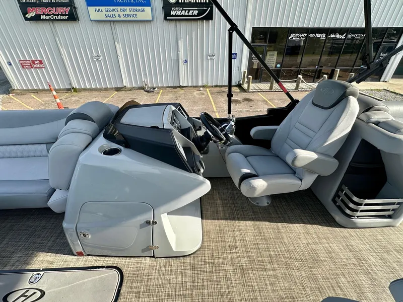 Slide: The Image of 2021 Harris Grand Mariner 250 boat interior with plush seating and modern dashboard controls. - 16