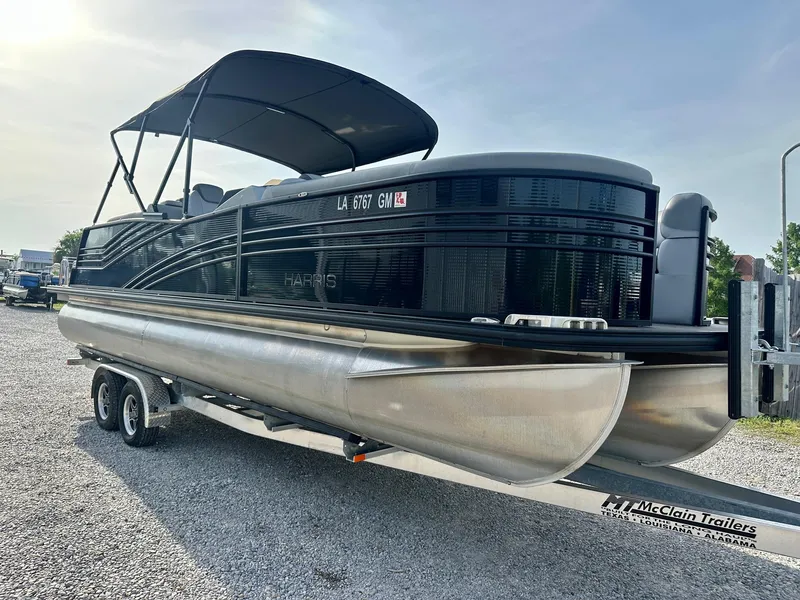 Slide: The Image of 2021 Harris Grand Mariner 250 pontoon boat on trailer, parked on gravel. - 7