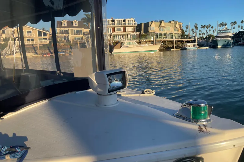 Slide: The Image of 2017 ElectraCraft 18 LS boat on calm water, with waterfront homes in the background. - 15