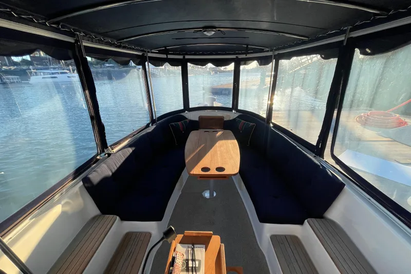Slide: The Image of Interior of 2017 ElectraCraft 18 LS boat with seating and table, docked by the water. - 5