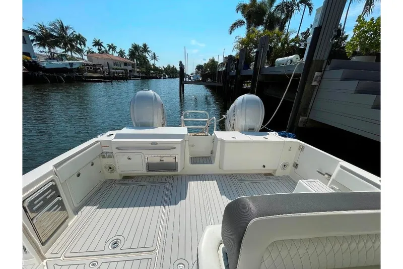 Slide: The Image of 2021 World Cat 400 DC-X boat with spacious deck, docked by palm-lined canal. - 20