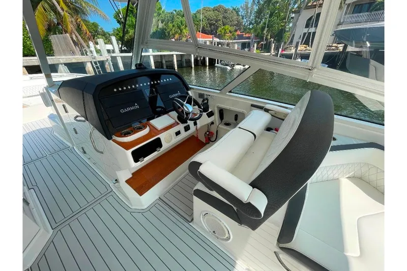 Slide: The Image of 2021 World Cat 400 DC-X helm with Garmin displays, luxurious seating, and waterfront view. - 24