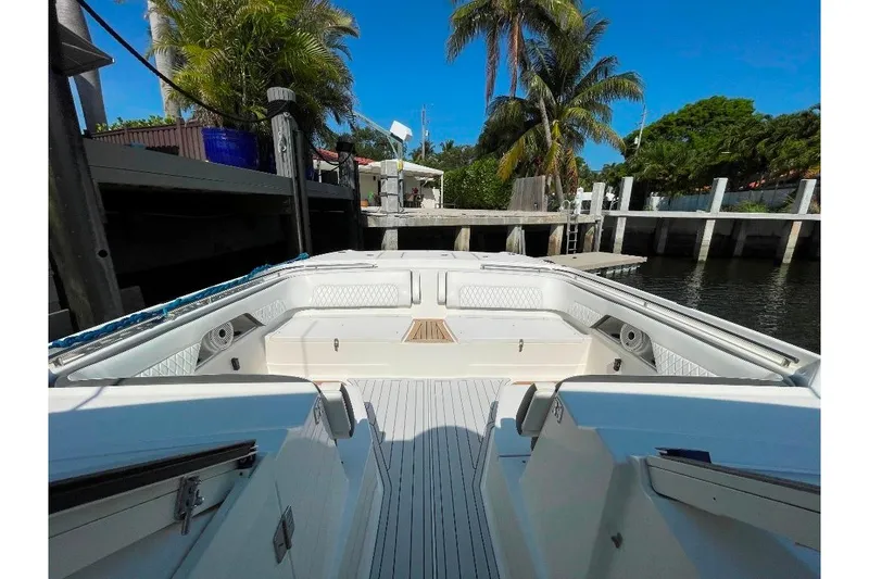 Slide: The Image of 2021 World Cat 400 DC-X boat interior at dock, surrounded by palm trees. - 26