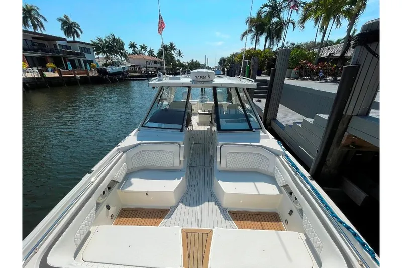Slide: The Image of World Cat 400 DC-X 2021 boat docked in a sunny waterfront setting with palm trees. - 27