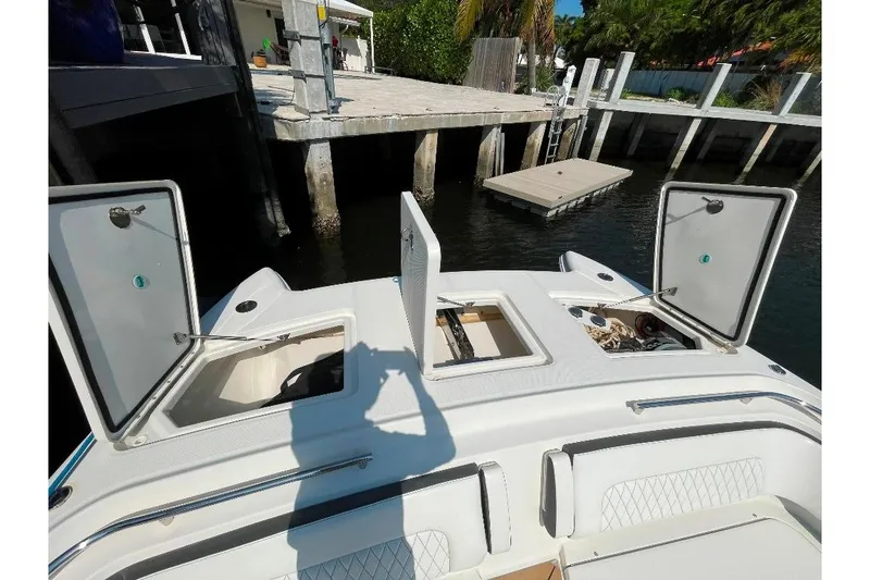 Slide: The Image of 2021 World Cat 400 DC-X boat with open storage compartments at dockside. - 28