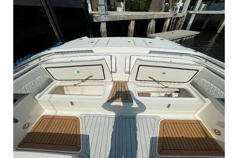 Slide: The Image of 2021 World Cat 400 DC-X boat deck with open storage compartments, dockside view. - 32