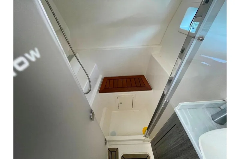 Slide: The Image of 2021 World Cat 400 DC-X boat interior with shower and wooden seat. - 36