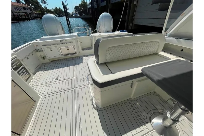 Slide: The Image of 2021 World Cat 400 DC-X boat interior with seating and storage, docked by the water. - 46