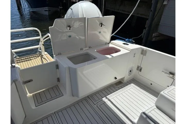 Slide: The Image of 2021 World Cat 400 DC-X boat deck with storage compartments and seating area. - 61