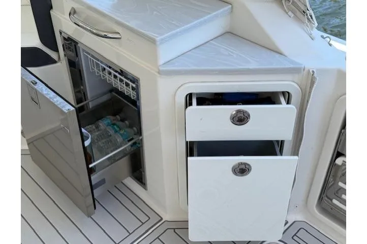 Slide: The Image of 2021 World Cat 400 DC-X boat interior with open fridge and storage drawers. - 63