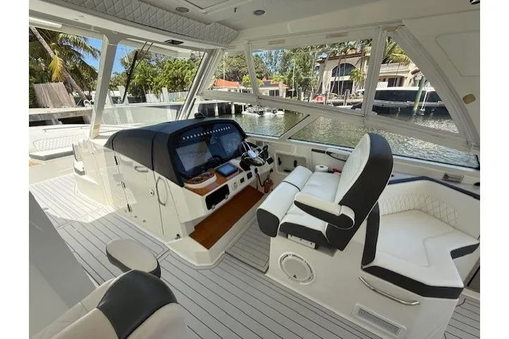 Slide: The Image of 2021 World Cat 400 DC-X boat interior with modern helm and seating, docked by waterfront homes. - 68